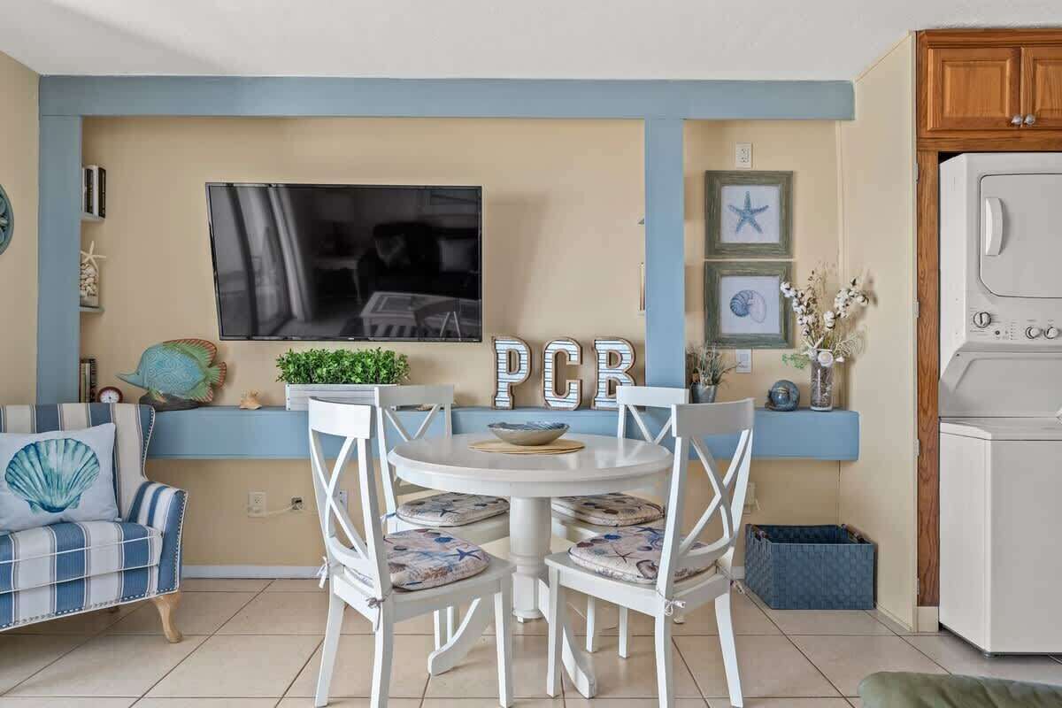 Un espacio habitable compacto con comedor, televisión y lavadora.