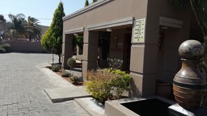 A building with a sign indicating room numbers 1-6, 7-10, 11-14, 15-17, and 18-19. - Times Premier Lodge (Vryburg)