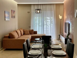 Appartement Deluxe | Coin séjour | Télévision LED de 55 pouces avec chaînes par satellite, télévision