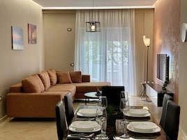 Apartamento Deluxe | Zona de estar | Televisión LED de 55 pulgadas con canales por satélite, una televisión