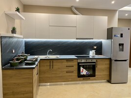 Apartamento Deluxe | Cocina privada | Frigorífico grande, microondas, horno y placa de cocina