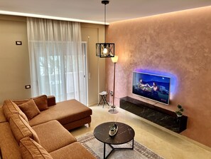 Appartement Deluxe | Coin séjour | Télévision LED de 55 pouces avec chaînes par satellite, télévision