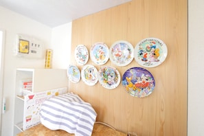 A bedroom with a bed, a wooden headboard, and a wall decorated with Christmas-themed plates.