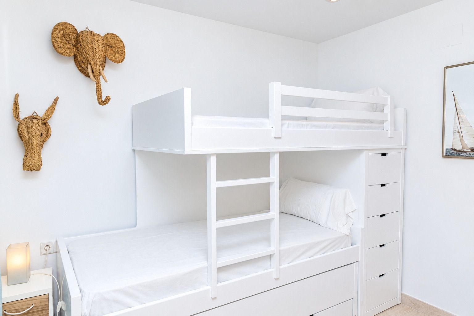 Un letto a castello con una scala, un comodino e una mensola a parete con oggetti decorativi.
