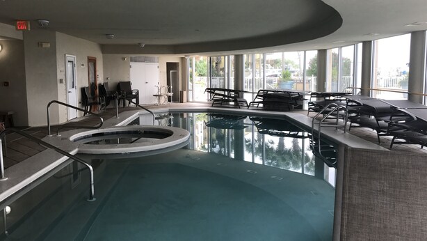 An indoor pool with a hot tub, lounge chairs, and a view of the outside. - Great 3Br/2Ba Waterfront Condo in OBA near Perdido Pass (Orange Beach)