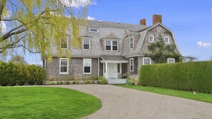 A two-story house with a front porch, a driveway, and a well-maintained lawn. - Elegant Watefront home with Oversized Gunite Heated Pool, Tennis, Living... (Water Mill)