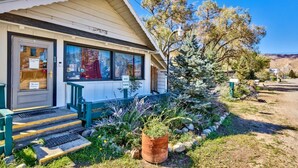 A guesthouse with a porch, steps, and a sign indicating guest parking.