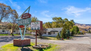 A motel sign with amenities listed, including TV, HBO, Wi-Fi, and various food and drink options.