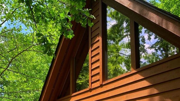 Eine Holzterrasse mit Gartenmöbeln und einem roten Sonnenschirm.