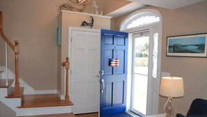 Una escalera que lleva a una puerta con un panel azul y una pequeña decoración con la bandera estadounidense.