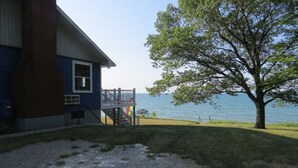 A house with a balcony overlooking a body of water. - Cabin with 150 ft of beach front and amazing sunsets and sunrises! (Caseville)