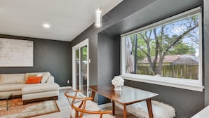 A modern living room with a sofa, dining table, and chairs. - Just updated,with putting green. 5mi 2 Airpt&Dwtn. Great for family & business.  (Austin)