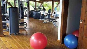 Ein Fitnessstudio mit Trainingsgeräten und Übungsbällen.