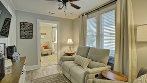 A living room with a ceiling fan, a sofa, a lamp, and a window with blinds. - "Bee Haven" Cottage Retreat Near Colonial Williamsburg (Gloucester)