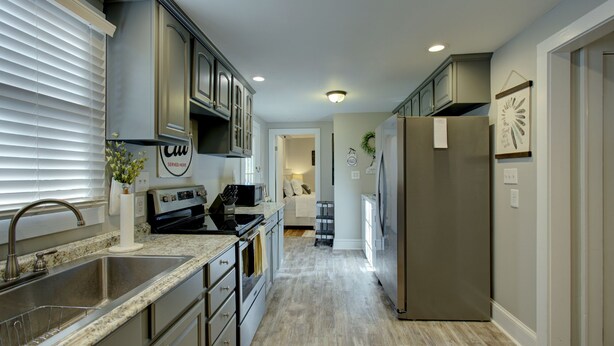 A modern kitchen with a stainless steel sink, a built-in oven, and a refrigerator. - "Bee Haven" Cottage Retreat Near Colonial Williamsburg (Gloucester)