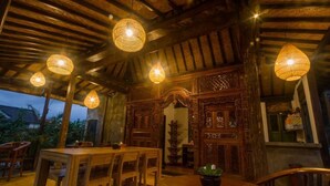 Un intérieur en bois comprenant un coin repas avec une table et des chaises, ainsi qu’une porte décorative en bois.