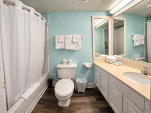 A bathroom with a toilet, bidet, sink, and mirror. - Oceanfront Luxe SM |  Fifty-One Thirty-One (Myrtle Beach)