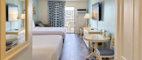 Une chambre d’hôtel avec deux lits, un coin repas et une télévision.