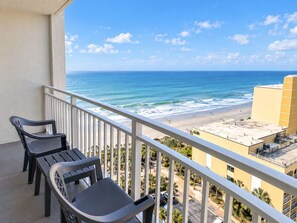 A balcony with two chairs overlooking a beach and ocean. - Oceanfront Luxe SM |  Fifty-One Thirty-One (Myrtle Beach)