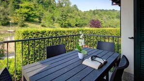 Ein Balkon mit Tisch, Stühlen und einer Topfpflanze.