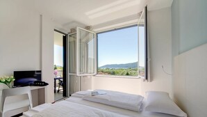 Un dormitorio con una cama, un escritorio y un televisor.
