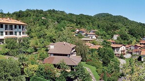 Zona residencial con casas en una ladera, rodeada de vegetación.
