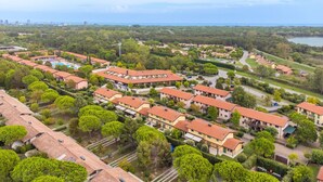 Zona residencial con varios edificios, incluyendo un hotel de techos rojos y una piscina.