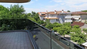 A balcony with a view of a residential area, including houses and trees. - Cosy apartment for 6 guests with WIFI, A/C, TV and balcony (Lignano Sabbiadoro)