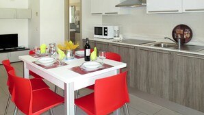 A modern kitchen with white cabinets, a microwave, a coffee maker, and a sink. - Cosy apartment for 6 guests with WIFI, A/C, TV and balcony (Lignano Sabbiadoro)