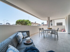 Un balcon avec un canapé, des chaises et une table.
