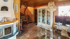 A spacious living area with a fireplace, a staircase, a glass cabinet with decorative items, and a chandelier. - 3 bedroom amazing home in Legbad (Legbad)