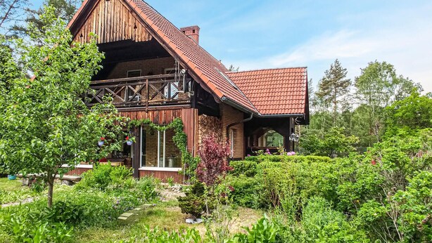 A wooden cabin with a sloped roof, surrounded by lush greenery and trees. - 3 bedroom amazing home in Legbad (Legbad)