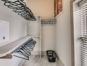 A compact, modern closet with multiple hanging spaces and a built-in laundry basket.
