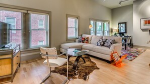 A modern living room with a sofa, a coffee table, a chair, and a rug.