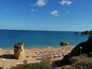 A beach with clear blue water, rocky formations, and a no dogs sign. - Coastal Escape •Steps to Beach •Pool • Inema Lagos (Lagos)