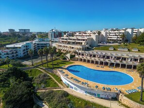 Um resort com uma piscina grande, vários edifícios e uma vista ampla da região.