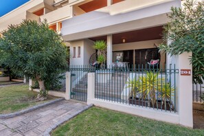 A residential building with a gated entrance, a visible number '204' on the wall, and a small front yard with a lawn and a few potted plants. - Coastal Escape •Steps to Beach •Pool • Inema Lagos (Lagos)