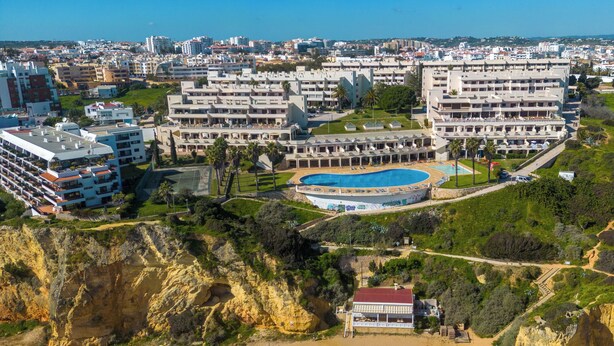Een kusthotel met meerdere gebouwen, een zwembad en een strandgedeelte.