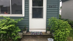 Une maison avec une porte blanche, une boîte aux lettres et le numéro « 8470 » peint sur le mur.
