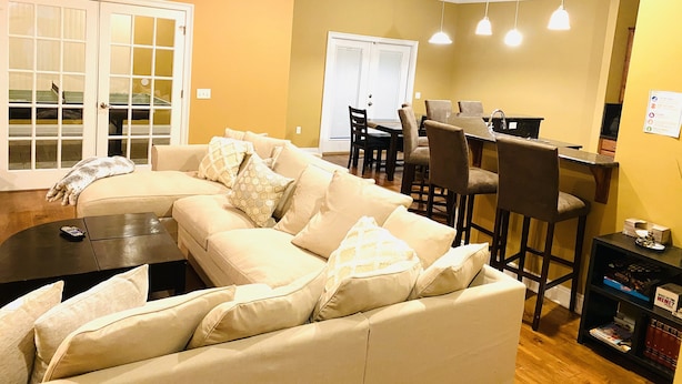 A living room with a beige sofa, a coffee table, and a dining area with a table and chairs. - Newly renovated modern, spacious & quiet location (Panama City)