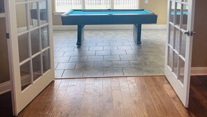 A pool table in a room with wooden flooring and large windows. - Newly renovated modern, spacious & quiet location (Panama City)