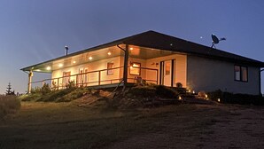 Une maison à deux étages avec un porche couvert et une antenne parabolique sur le toit.