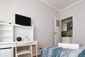 Ein Schlafzimmer mit einem Bett, einem Schreibtisch, einem Fernseher und einem Kleiderschrank.
