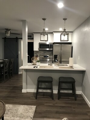 Enjoy cooking in this kitchen with a central island, stainless steel appliances, and pendant lighting.