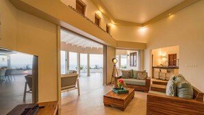 A spacious living area with a large TV, wooden furniture, and a view of the outdoors. - Villa Vila Blenchi - Coral Estate (Rif. St. Marie)