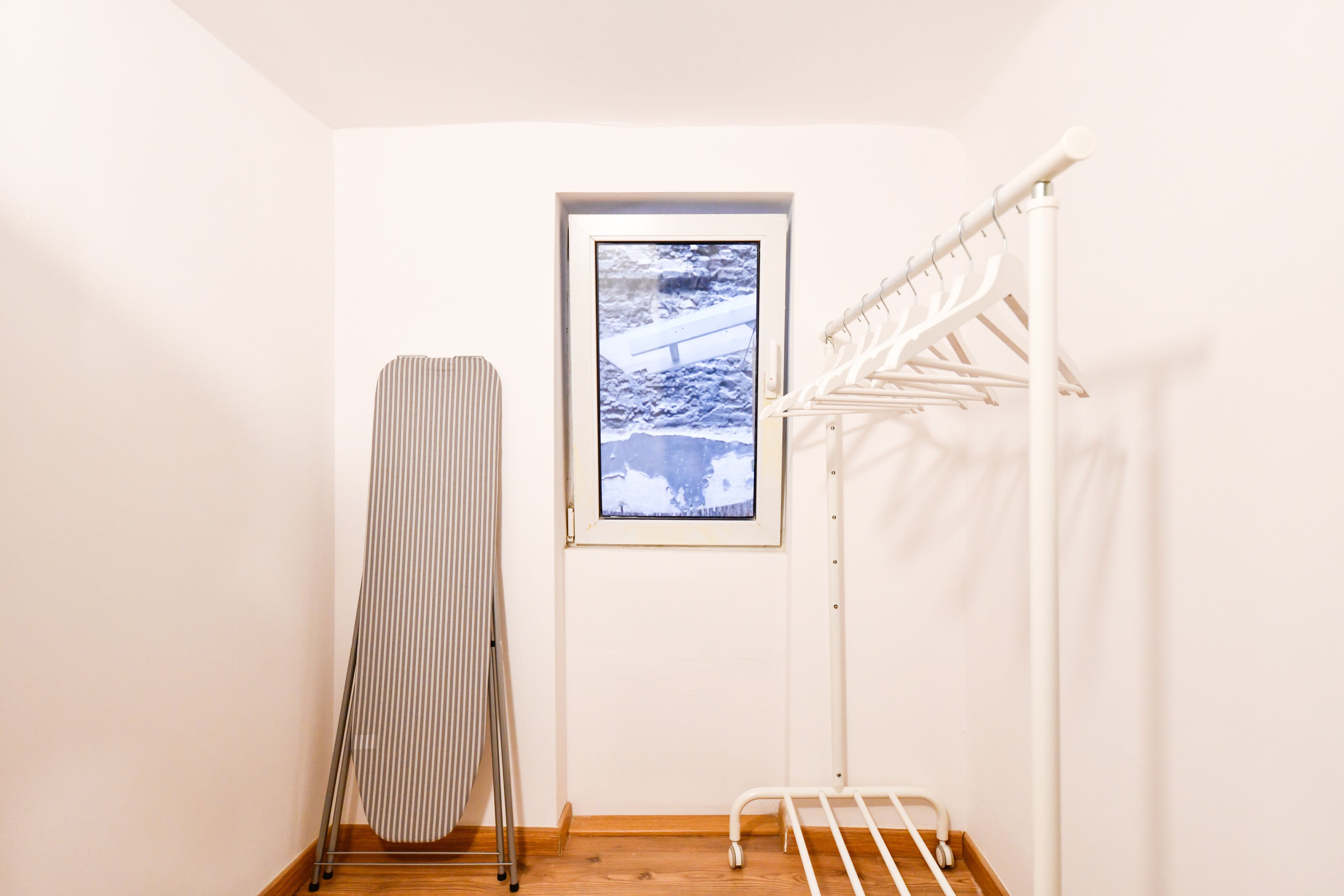 Una habitación con ventana, un tendedero y un radiador.