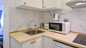 A compact kitchen with a sink, a microwave, a toaster, and a dishwasher. - Cosy flat in Dob street, Juliet (Budapest)