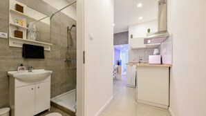 A modern bathroom with a sink, mirror, and shower. - Cosy flat in Dob street, Juliet (Budapest)