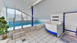 A swimming pool with a blue and white tub, a ladder, and a door with a blue frame. - Amazing home in Hvide Sande with sauna (Hvide Sande)
