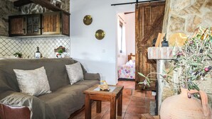 A cozy living room with a sofa, a small wooden table, and a stone wall. - Lovely home in Torrox with private swimming pool, can be inside or outside (Torrox)